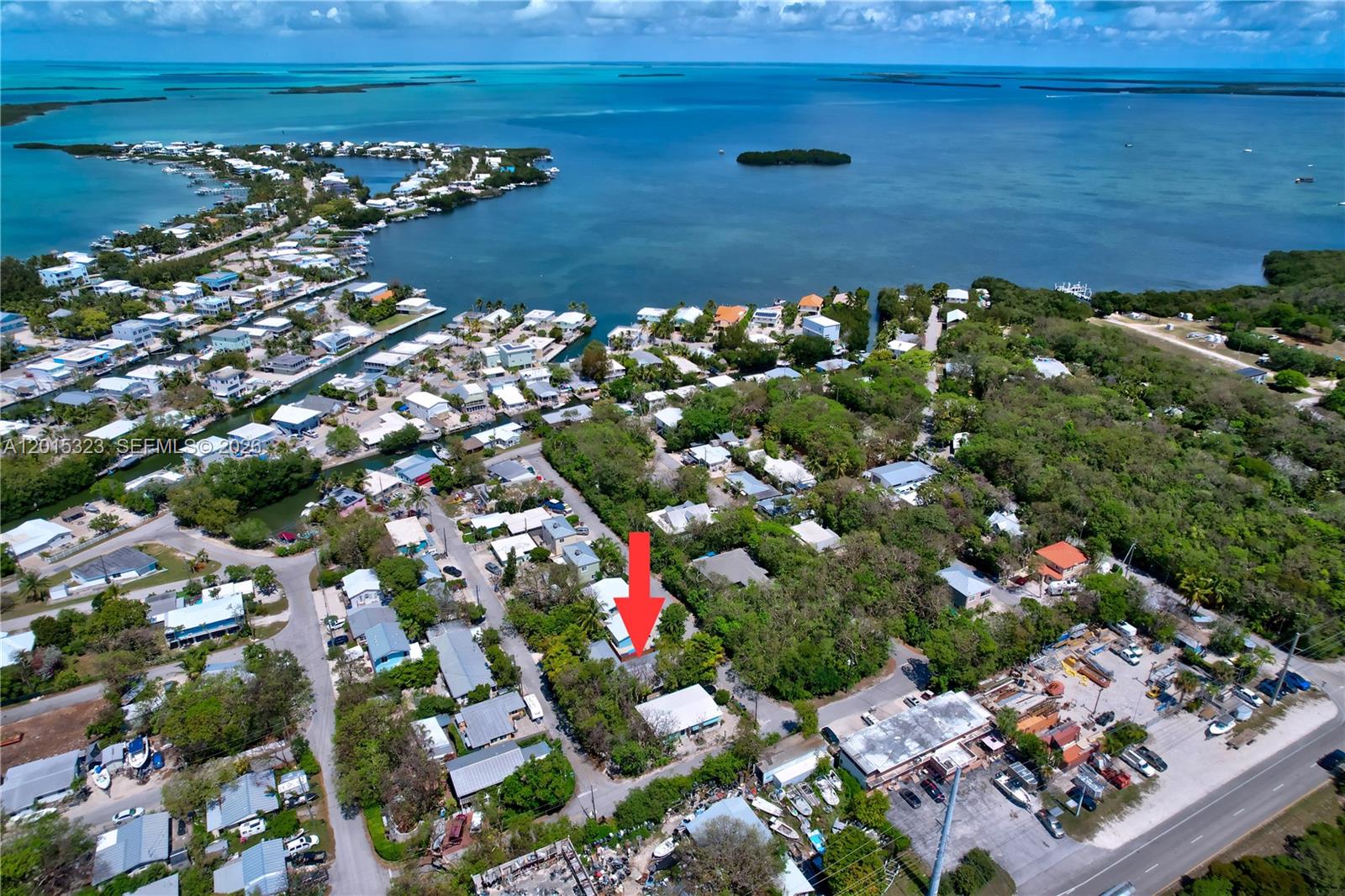 An aerial view shows a residential neighborhood with a red arrow pointing to a house — 85 Henry Morgan Dr, Key Largo FL 33037, KEY LARGO, FL