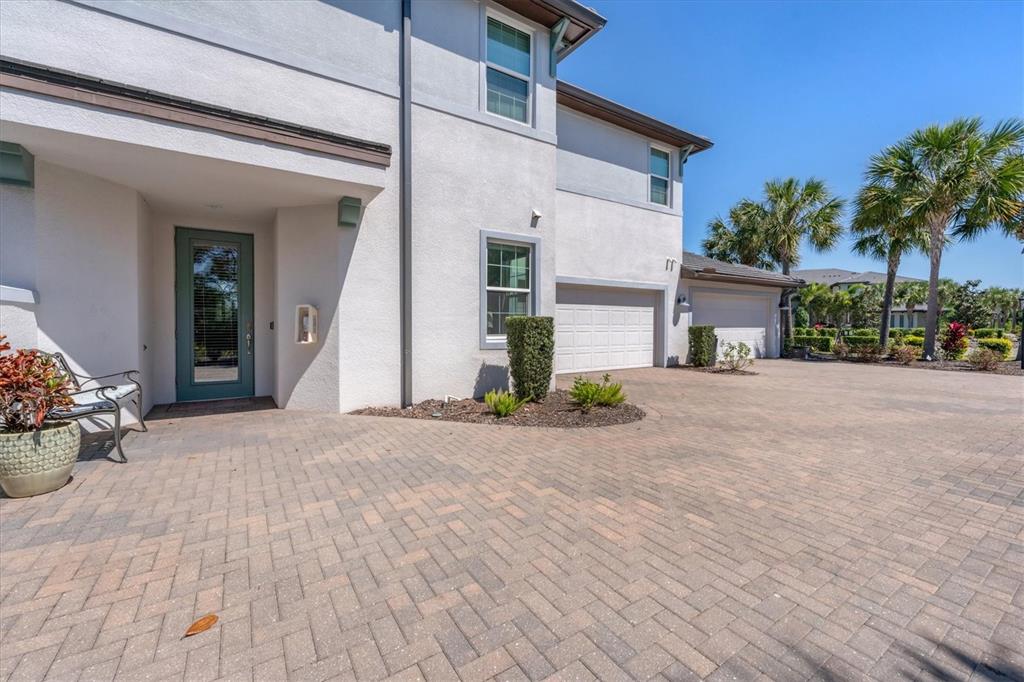 A two-story house with a paved driveway, two garage doors, and a front entryway — 7564 DIVOT LOOP, BRADENTON, FL
