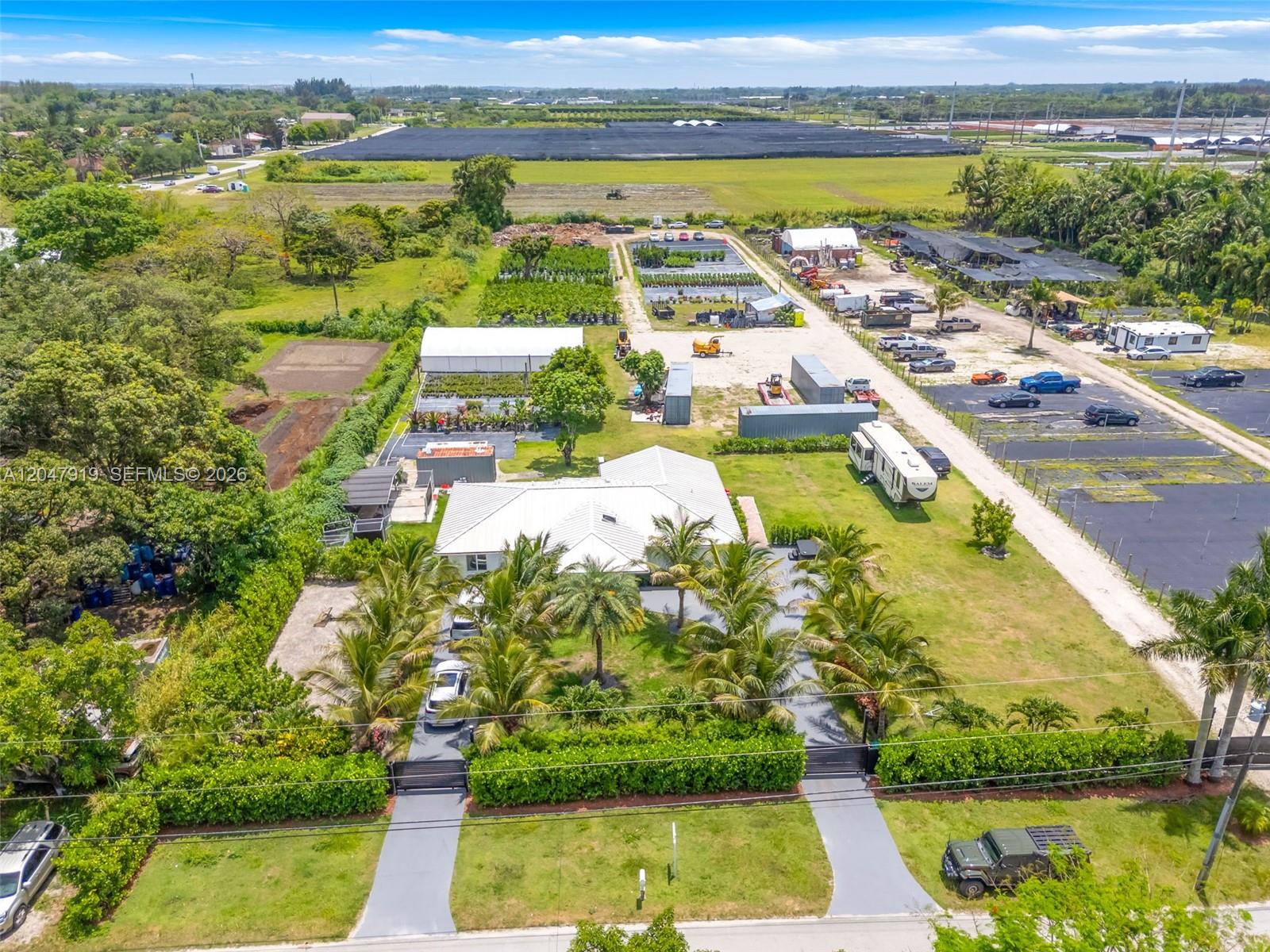 An aerial view shows a house with a white roof, palm trees, and surrounding property — 13770 SW 192nd St, Miami FL 33177, MIAMI, FL
