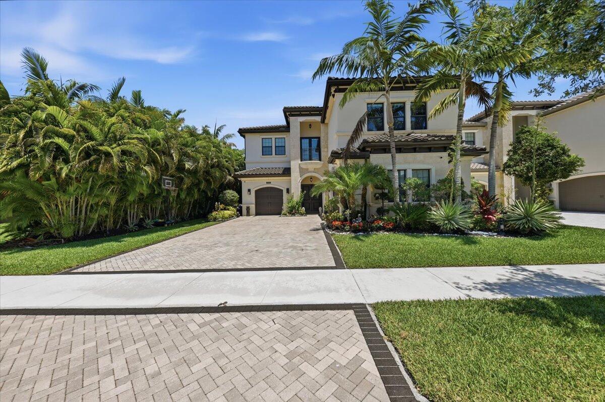 A two-story stucco house with a paved driveway, palm trees, and a landscaped front yard — 9769 Bozzano Drive, Delray Beach FL 33446, DELRAY BEACH, FL