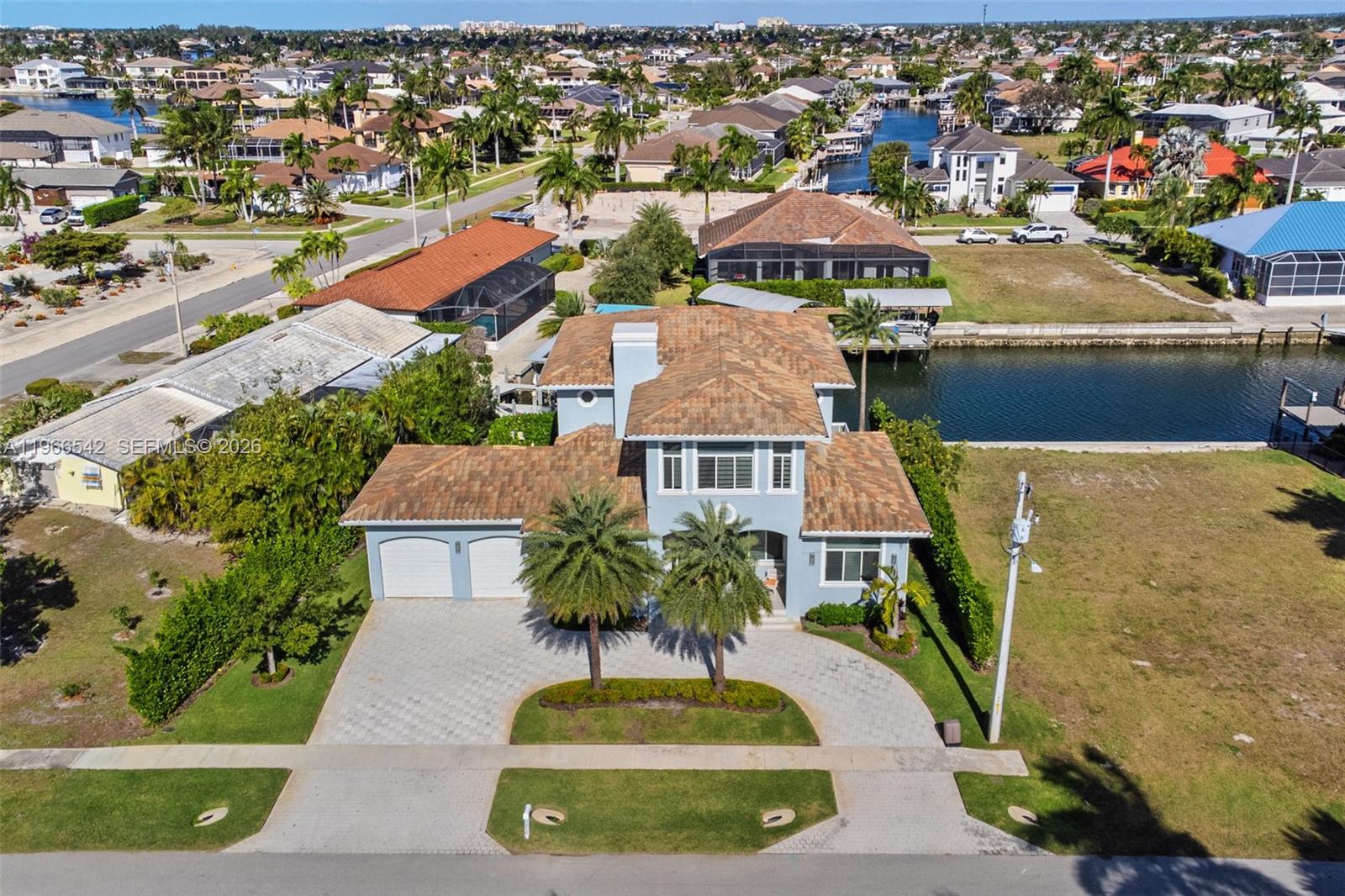 An aerial view of a two-story light blue house with a tiled roof and driveway — 1070 Dana CT, Marco Island FL 34145, MARCO ISLAND, FL