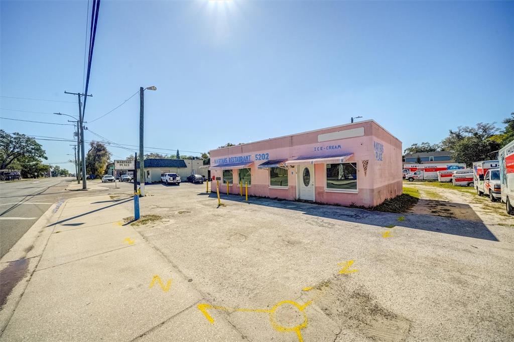 A pink, single-story commercial building with an ice cream sign stands on a paved lot — 5202 N NEBRASKA AVENUE E, TAMPA, FL