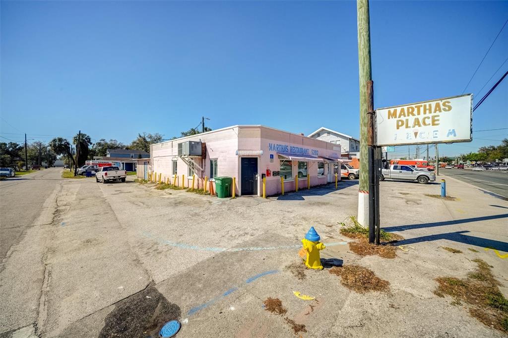 A pink, single-story commercial building with a parking lot and a prominent street sign — 5202 N NEBRASKA AVENUE E, TAMPA, FL