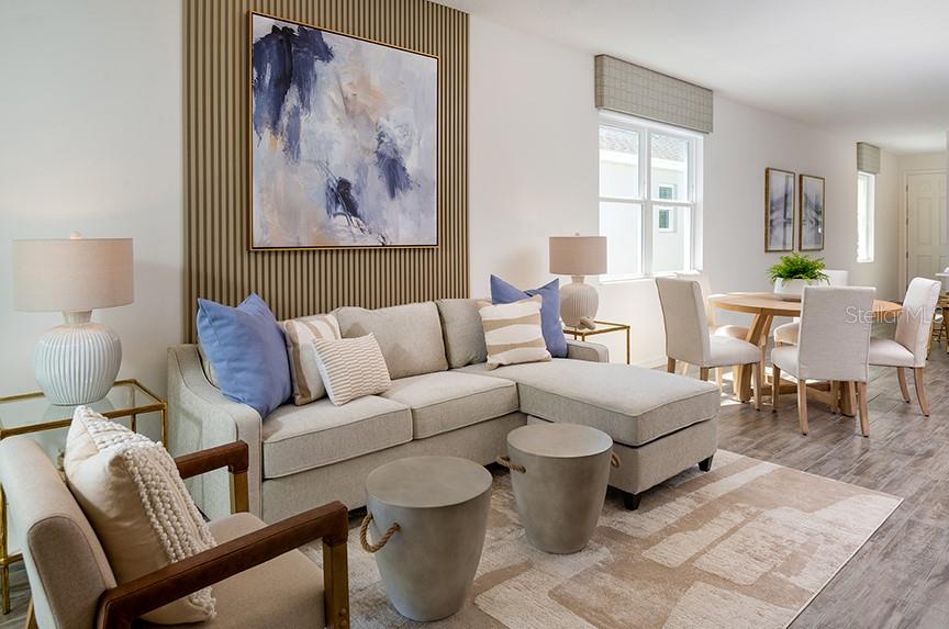 A living room features a sectional sofa, two accent chairs, and a dining area nearby — 2029 ANTHEM DRIVE, ORANGE CITY, FL