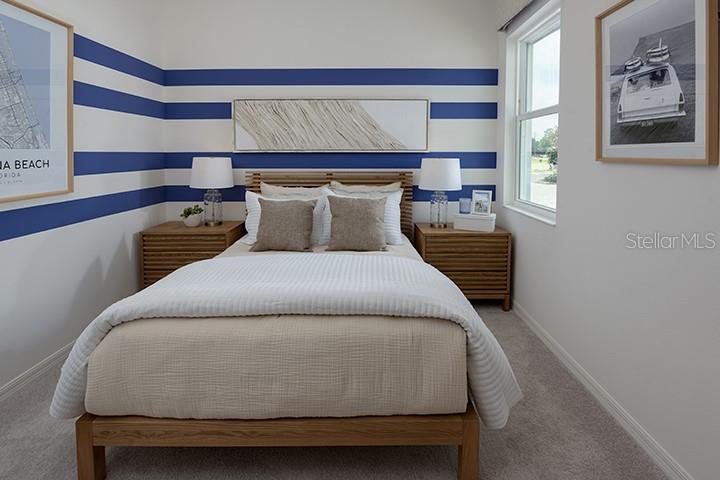 A bedroom features a bed with a striped blue and white accent wall — 2029 ANTHEM DRIVE, ORANGE CITY, FL