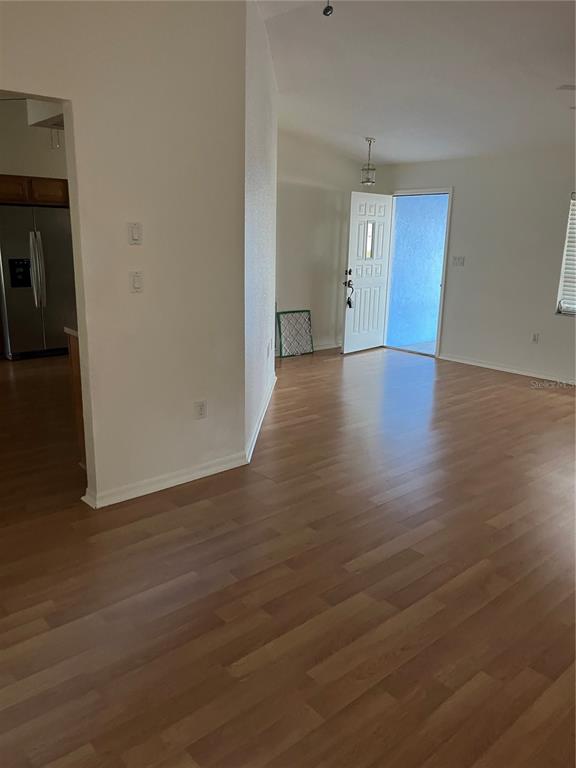 An interior view showing a living area with light wood flooring and an open entryway — 23076 AUGUST AVENUE, PORT CHARLOTTE, FL