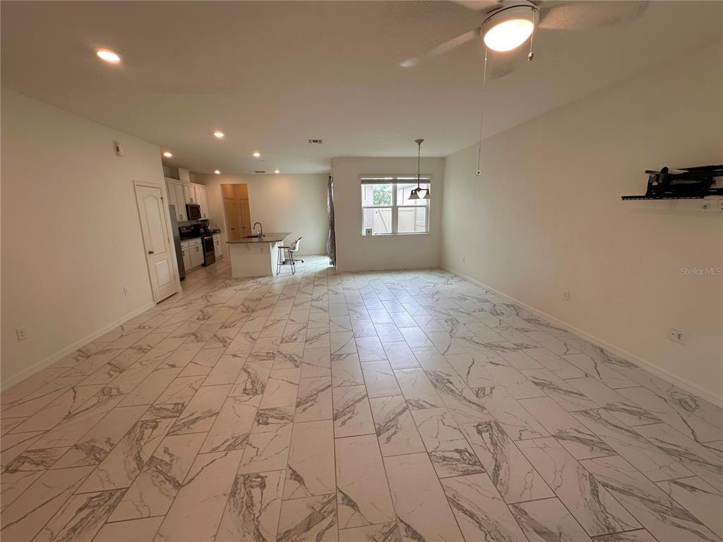 An open-concept living and kitchen area features white marble-patterned tile flooring and recessed lighting — 5844 SOTER LANE, WINDERMERE, FL