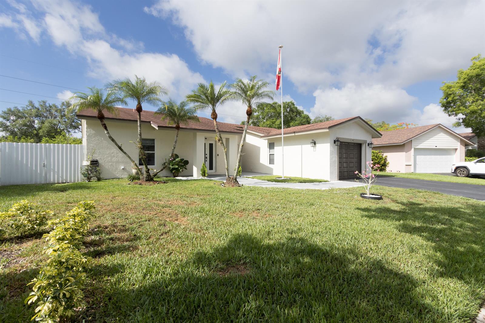 A single-story house with a white stucco exterior, palm trees, and a flag pole — 16942 SW 5th Way, Weston FL 33326, WESTON, FL