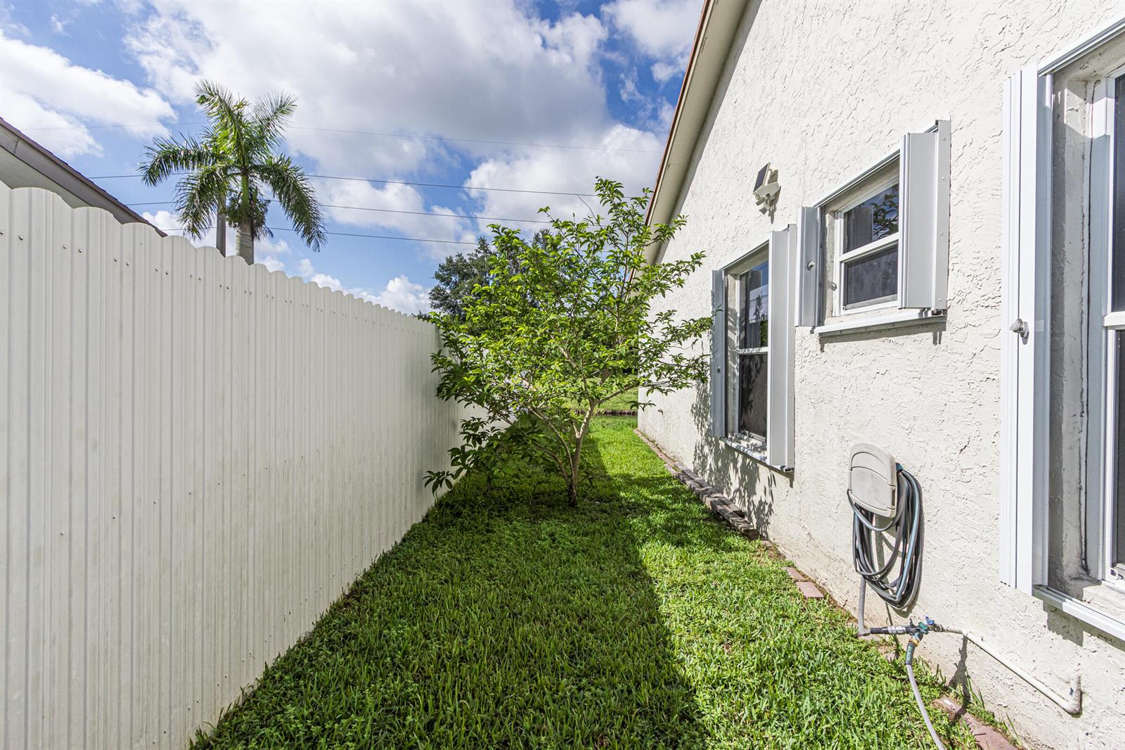 A side yard features a white fence, a small tree, and a stucco house exterior — 16942 SW 5th Way, Weston FL 33326, WESTON, FL