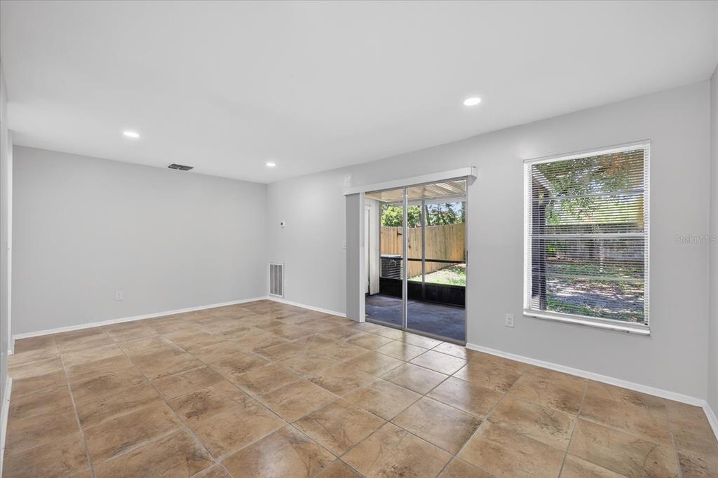 A room with light gray walls, tile flooring, a sliding glass door, and a window — 14024 VILLAGE TERRACE DRIVE, TAMPA, FL