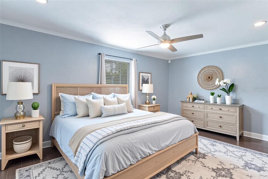 A bedroom features a light wood bed frame, blue bedding, and a matching dresser — 109 REBECCA DRIVE NE, WINTER HAVEN, FL