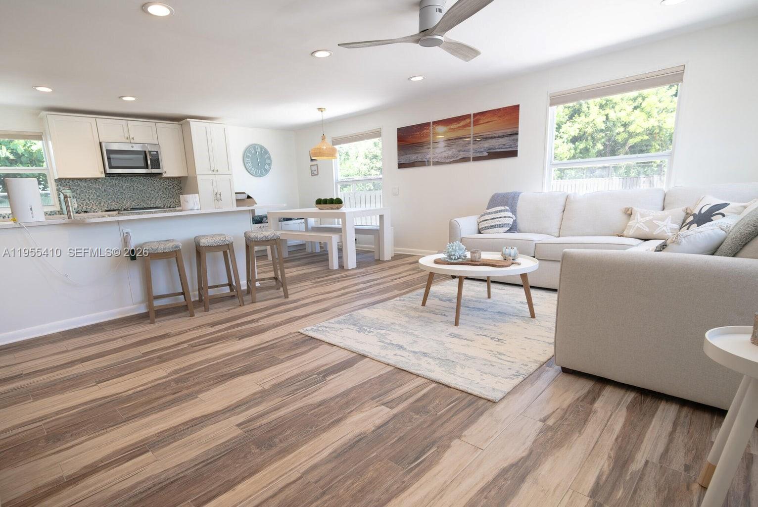 An open-concept living room and kitchen feature light wood-look flooring and white cabinetry — 212 Buttonwood Ln # 212, Key Largo FL 33070, KEY LARGO, FL