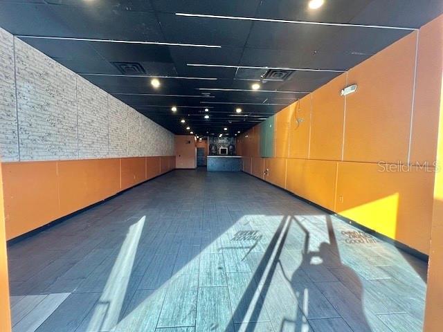 An empty commercial space features gray wood-look tile flooring, orange walls, and a black ceiling — 3900 S GOLDENROD ROAD UNIT 118, ORLANDO, FL
