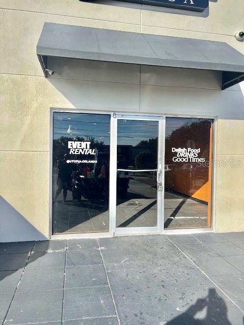 The exterior of a commercial storefront features a gray awning over a glass double door — 3900 S GOLDENROD ROAD UNIT 118, ORLANDO, FL