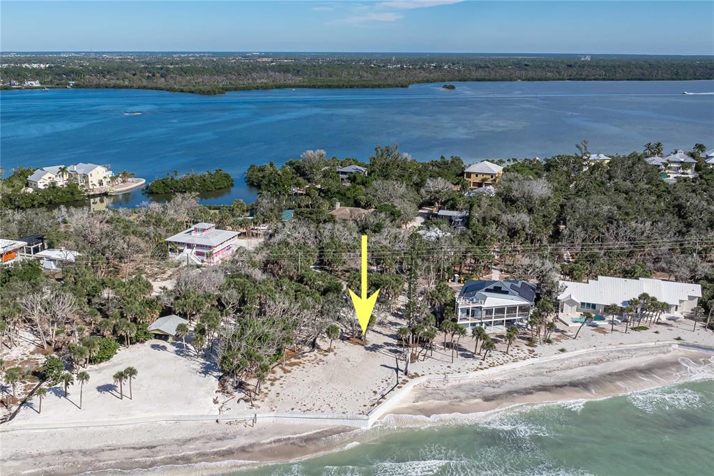 An aerial view shows a vacant beachfront lot marked by a yellow arrow — 7210 MANASOTA KEY ROAD, ENGLEWOOD, FL
