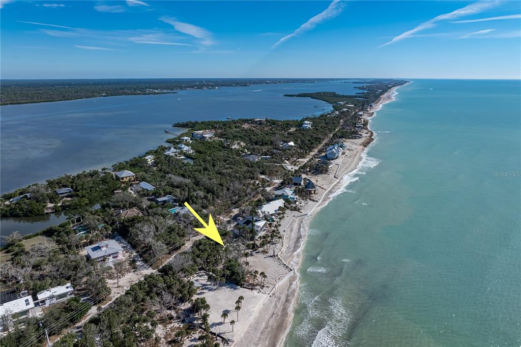 An aerial view shows a coastal property with a yellow arrow pointing toward a house — 7210 MANASOTA KEY ROAD, ENGLEWOOD, FL