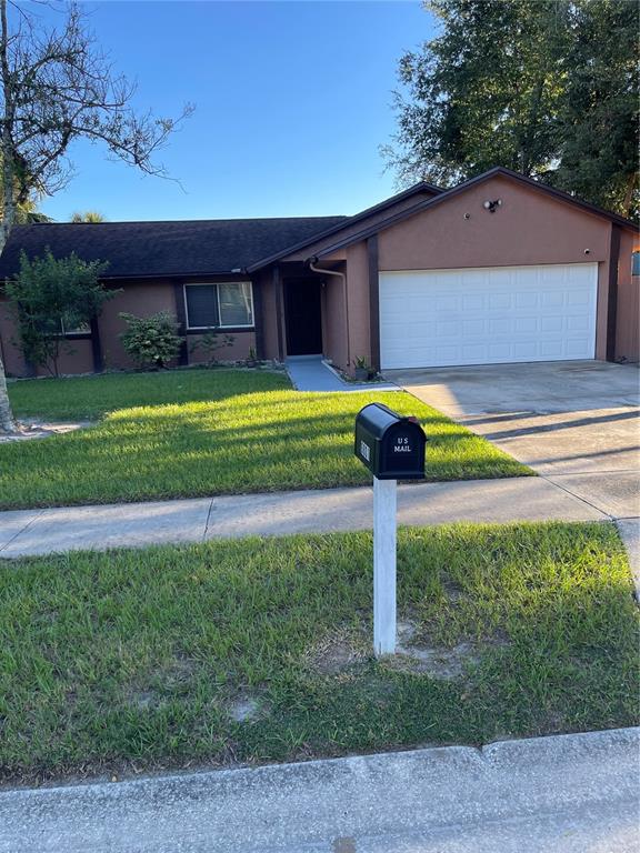 A single-story house with a brown exterior, a two-car garage, and a front lawn — 6801 COMPASS COURT, ORLANDO, FL
