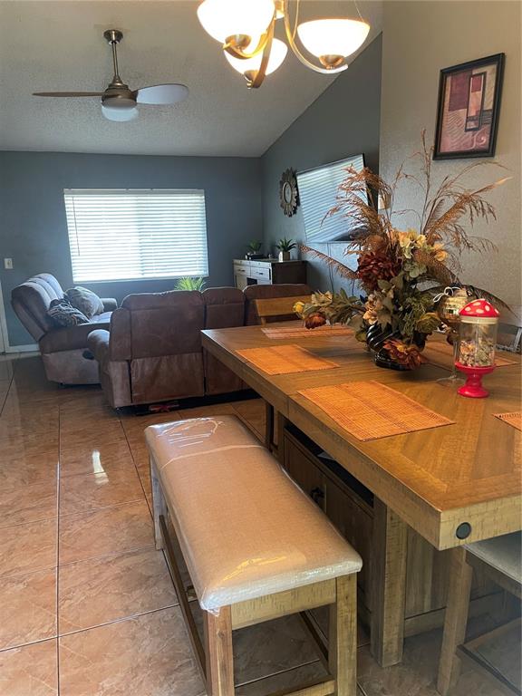 A dining area with a wooden table and bench sits in front of a living room — 6801 COMPASS COURT, ORLANDO, FL
