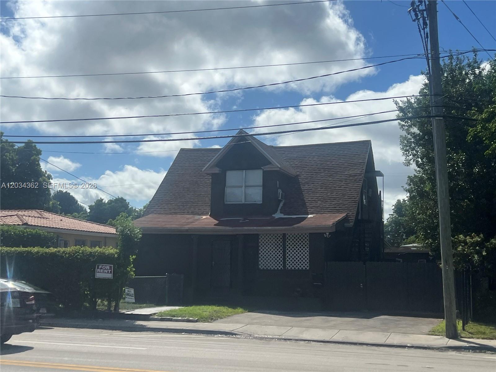 A dark-colored two-story house with a gabled roof and a front porch stands outdoors — 842 SW 12th Ave, Miami FL 33130, MIAMI, FL