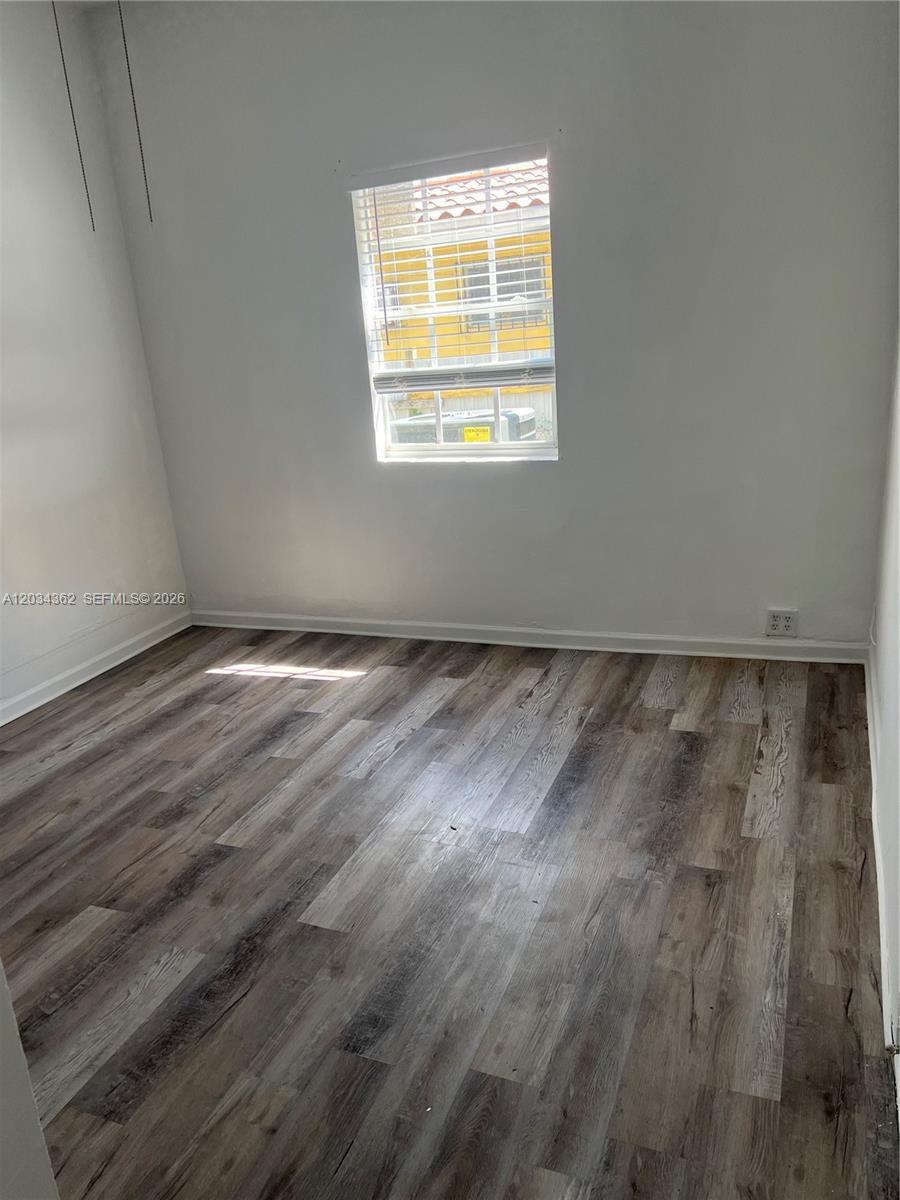 An empty room features white walls, wood-look vinyl flooring, and a single window — 842 SW 12th Ave, Miami FL 33130, MIAMI, FL