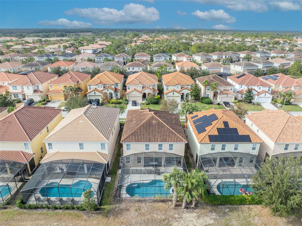 An aerial view of suburban houses with screened-in swimming pools and tile roofs — 5244 OAKBOURNE AVENUE, DAVENPORT, FL