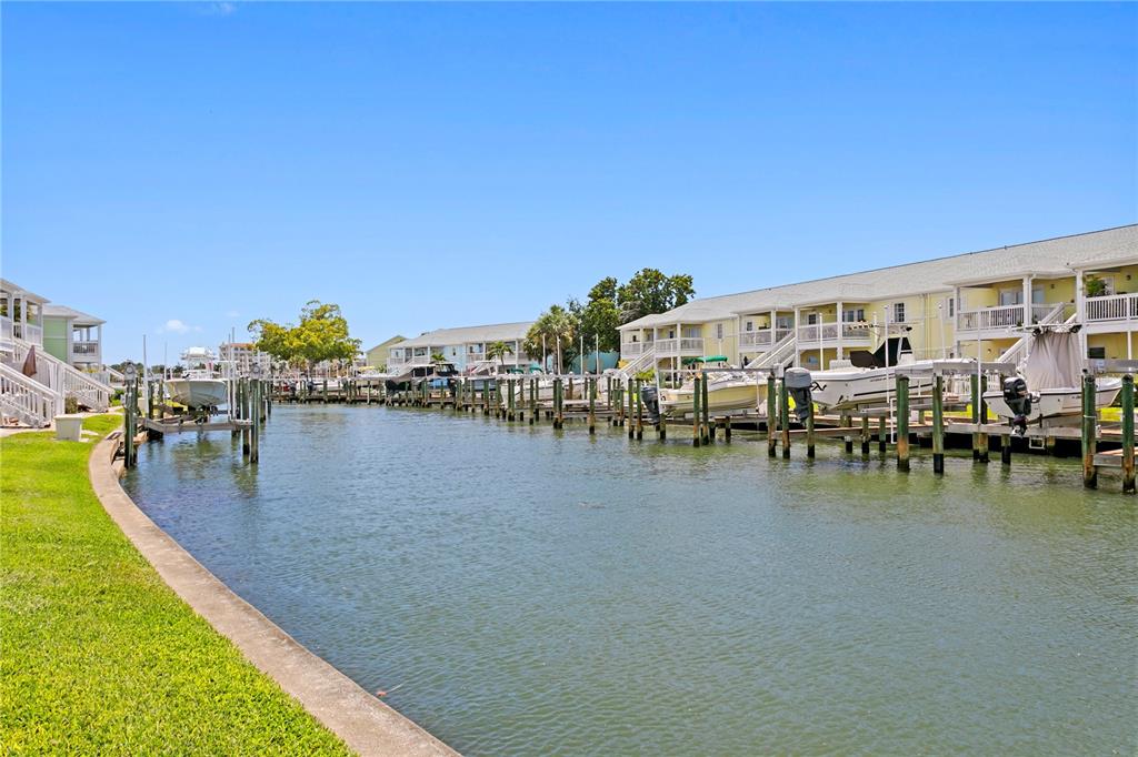 A canal lined with boat docks and residential buildings under a clear blue sky — 00 COQUINA KEY DRIVE SE UNIT 107SS, ST PETERSBURG, FL