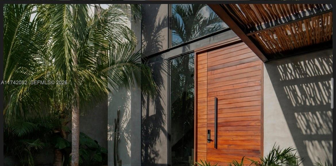A modern home entrance features a horizontal wood door, glass panels, and palm tree shadows — Tulum region 15 Mnz 327 lotes 007, ., .