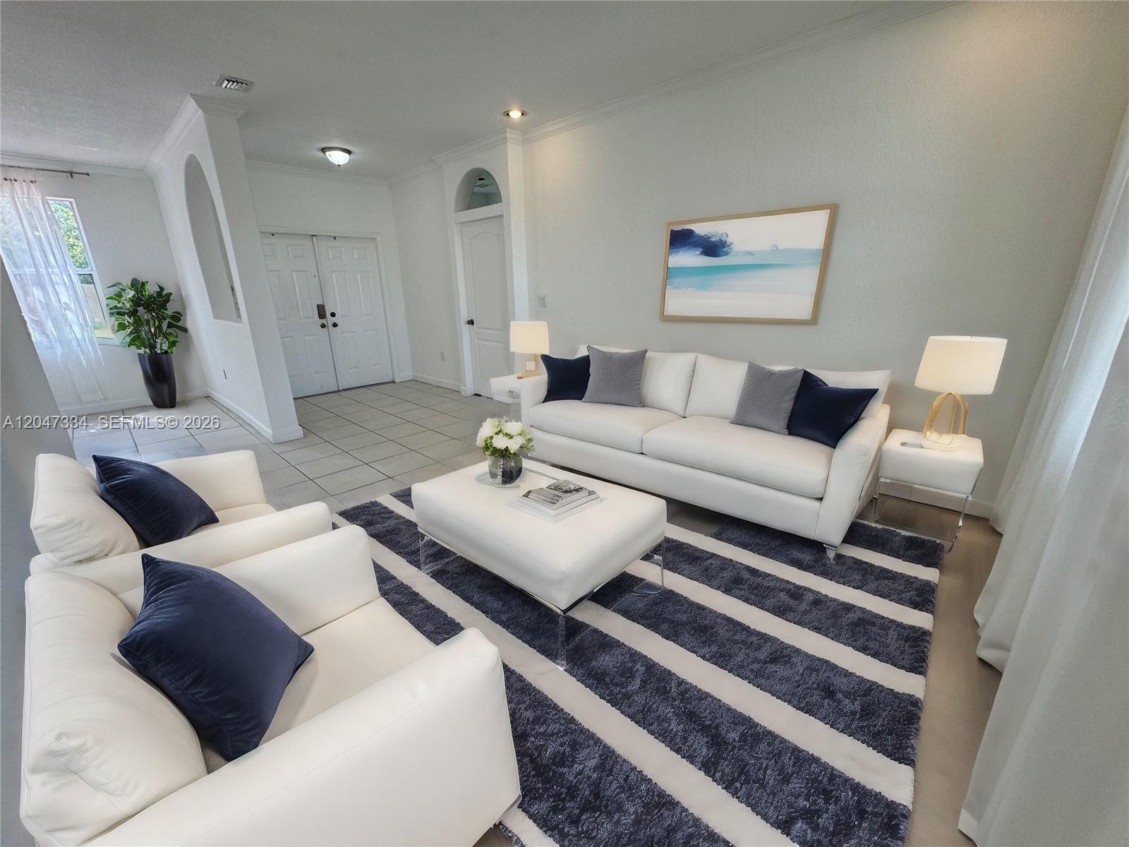 A living room features white sofas, a striped rug, and a central ottoman — 3523 SW 169th Ter, Miramar FL 33027, MIRAMAR, FL
