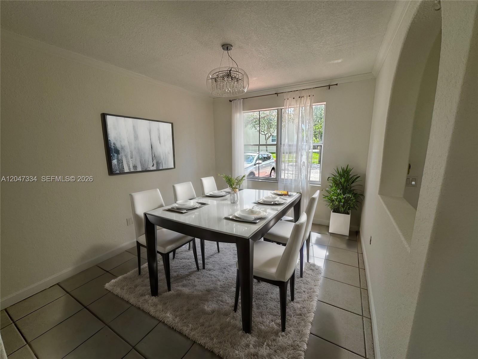 A dining room features a white table, six chairs, a chandelier, and a shaggy rug — 3523 SW 169th Ter, Miramar FL 33027, MIRAMAR, FL