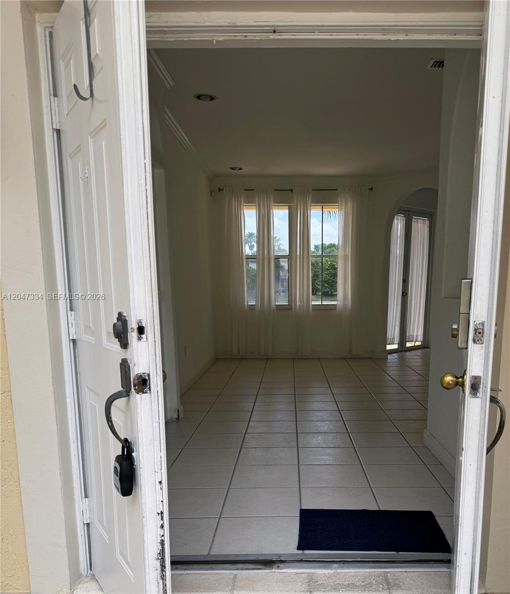 An open front door reveals a tiled entryway leading to a room with large windows — 3523 SW 169th Ter, Miramar FL 33027, MIRAMAR, FL