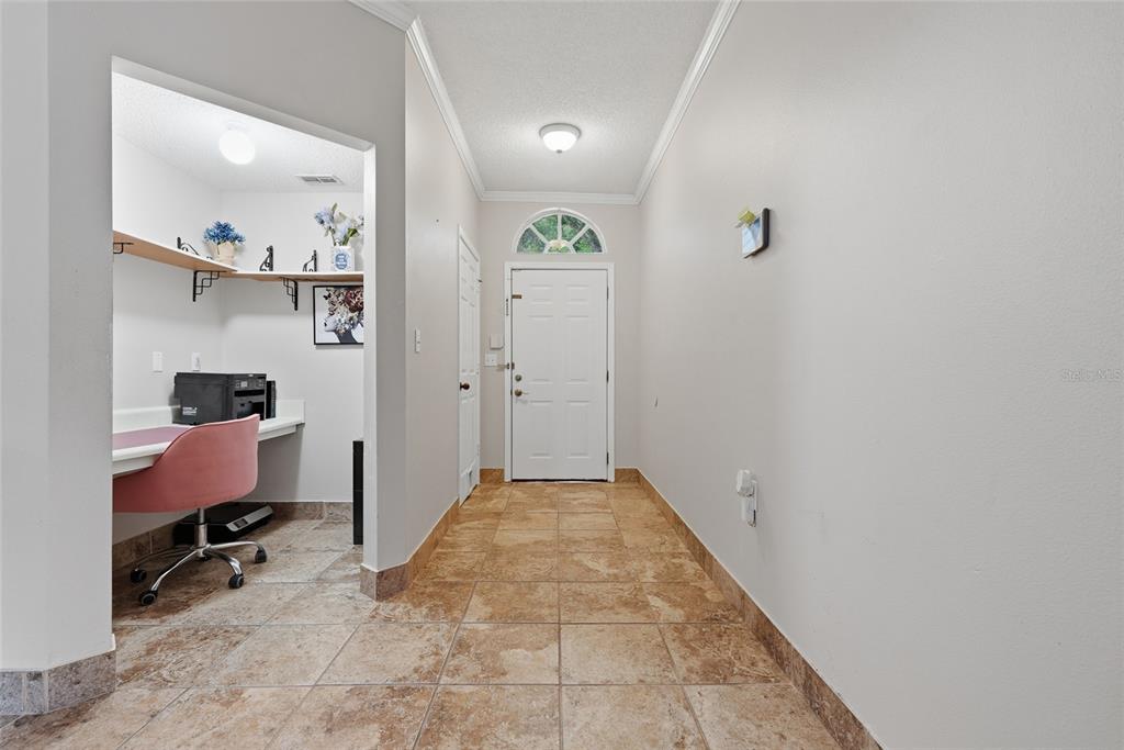 A tiled entryway features a white front door and an adjacent built-in office nook — 10000 SW 52ND AVENUE UNIT 71, GAINESVILLE, FL