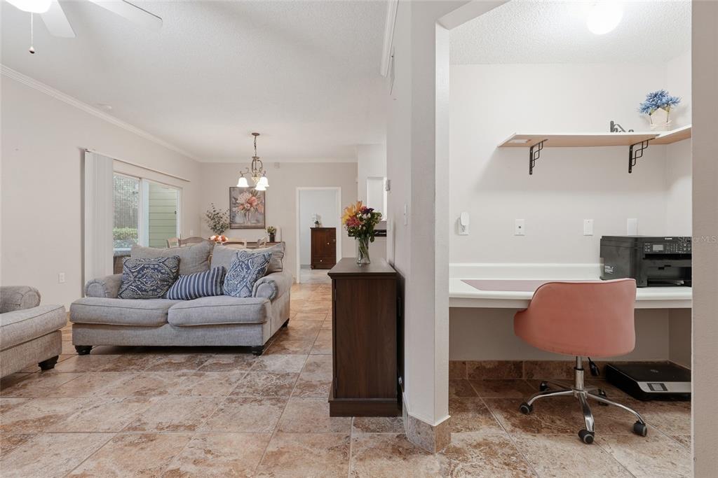A living room with tile floors and a sofa sits next to a small office nook — 10000 SW 52ND AVENUE UNIT 71, GAINESVILLE, FL