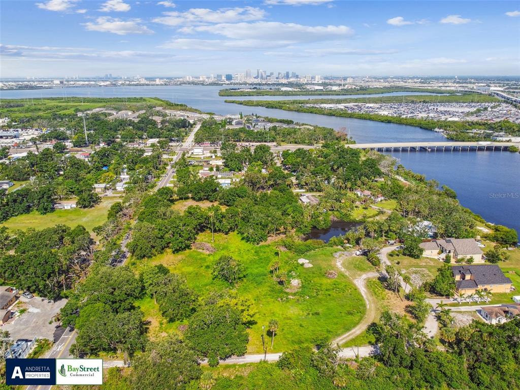 An aerial view shows a large, grassy vacant lot near a body of water — 5116 PALM RIVER ROAD, TAMPA, FL