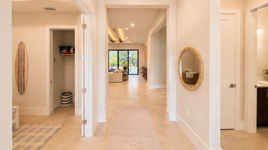 A hallway with light tile floors leads to an open living area with large glass doors — 269 BLUE PEARL COURT, SARASOTA, FL
