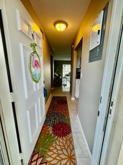 A narrow entryway features a floral runner rug, a white door with a flamingo decoration, and tile flooring — 2615 Garden Drive S # 101, Lake Worth FL 33461, LAKE WORTH, FL