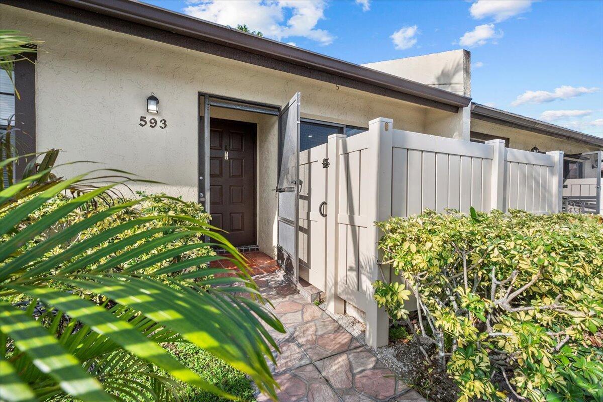 A stone walkway leads to the front entrance of a home with a privacy fence — 593 Banks Road # 593, Margate FL 33063, MARGATE, FL