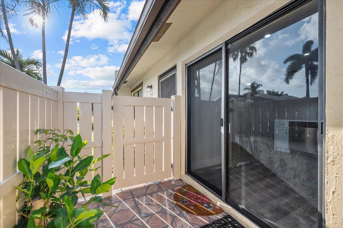 A patio area features a white gate, tiled flooring, and a sliding glass door — 593 Banks Road # 593, Margate FL 33063, MARGATE, FL