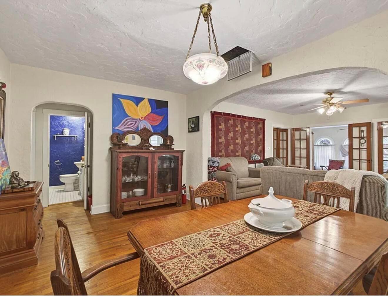 A dining room with hardwood floors, a wooden hutch, and an arched doorway to a bathroom — 705 Lytle Street, West Palm Beach FL 33405, WEST PALM BEACH, FL