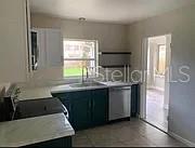 A kitchen features dark green cabinets, a stainless steel dishwasher, and a window above the sink — 981 ARAGON AVENUE, WINTER PARK, FL