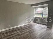 An empty room features light gray walls, wood-look flooring, and a large window — 981 ARAGON AVENUE, WINTER PARK, FL
