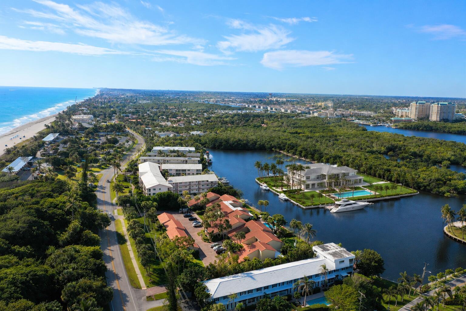 An aerial view shows a coastal neighborhood with multi-family buildings, a large waterfront estate, and vegetation — 6522 N Ocean Boulevard, Ocean Ridge FL 33435, OCEAN RIDGE, FL