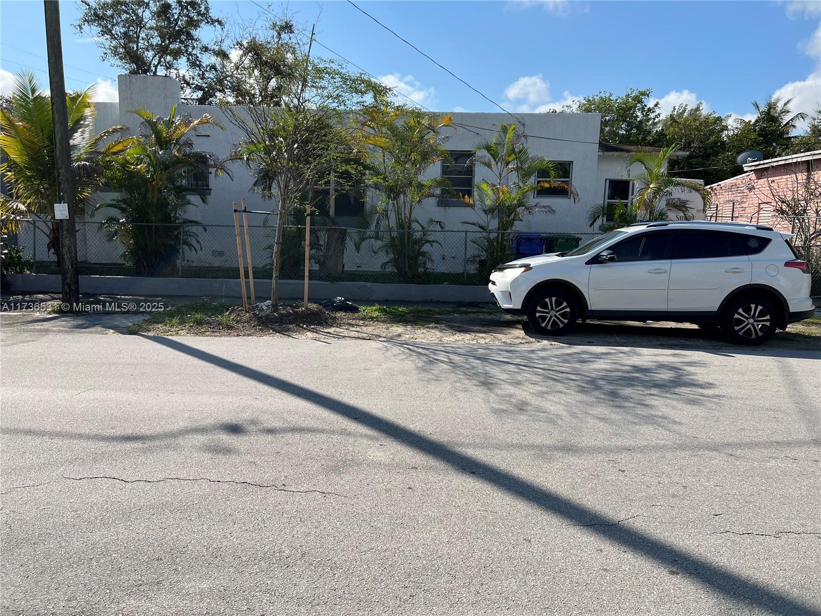 A white SUV is parked in front of a single-story house with a chain-link fence — 6730 NE MIAMI PL, Miami FL 33138, MIAMI, FL