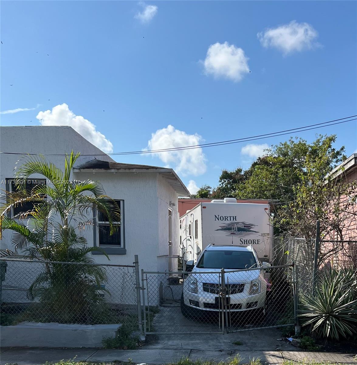 A white house with a chain-link fence, a parked car, and a camper trailer — 6730 NE MIAMI PL, Miami FL 33138, MIAMI, FL