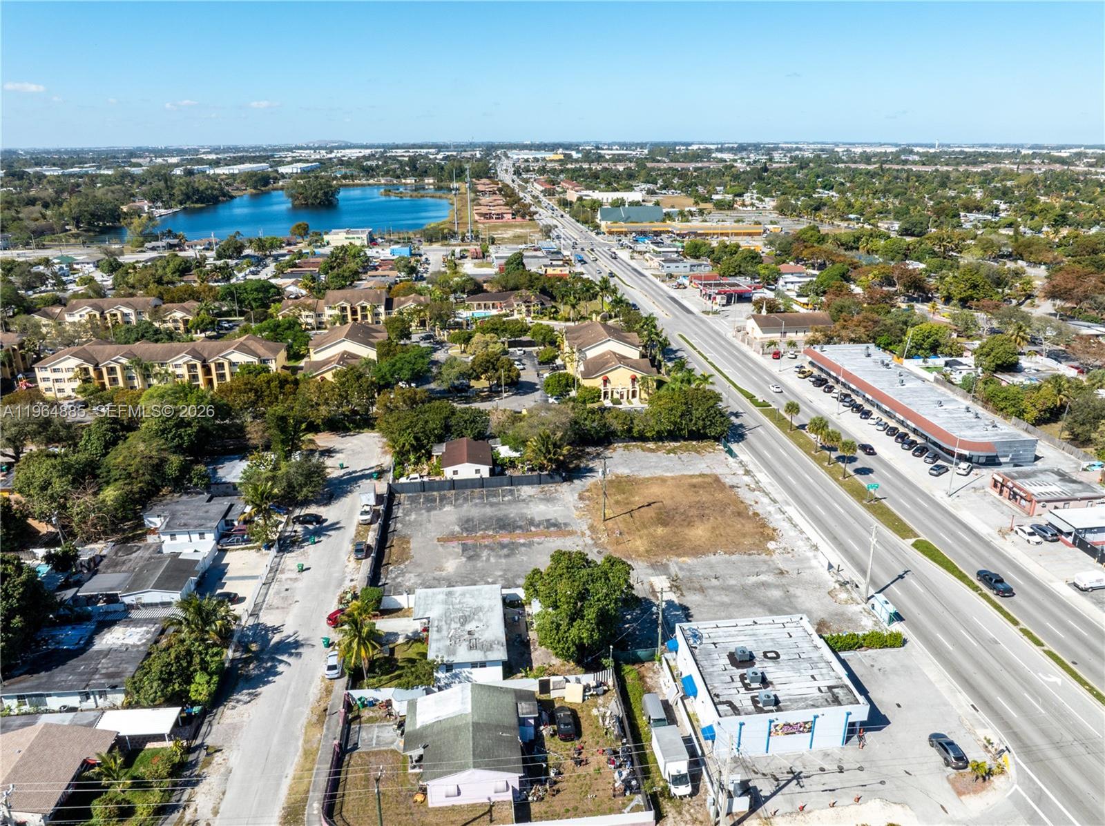 An aerial view shows a commercial property with a vacant lot and surrounding suburban buildings — 1410 NW 119th St, Miami FL 33167, MIAMI, FL
