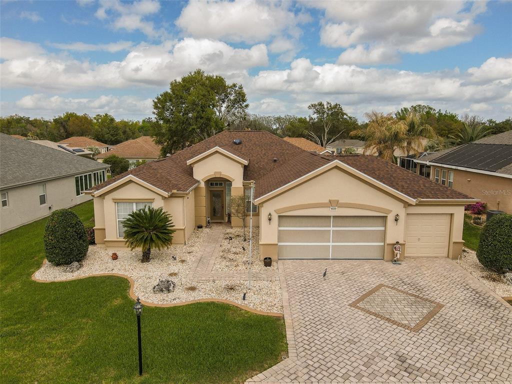 An aerial view of a single-story house with a paved driveway and landscaped front yard — 9435 SE 124TH PLACE, SUMMERFIELD, FL