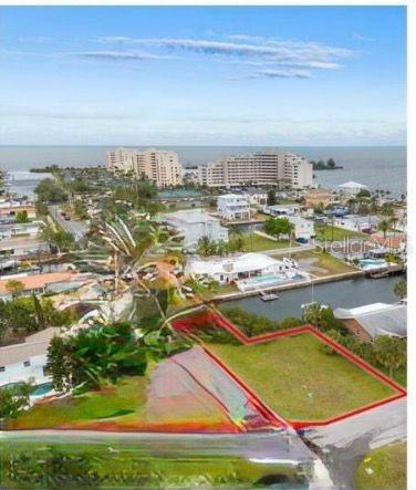 An aerial view shows a vacant waterfront lot outlined in red near a residential canal — Lot 20 MALCOM AVENUE, HUDSON, FL