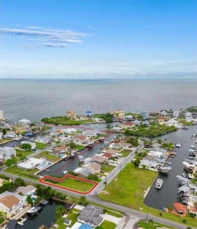 An aerial view shows a vacant waterfront lot outlined in red within a residential neighborhood — Lot 20 MALCOM AVENUE, HUDSON, FL