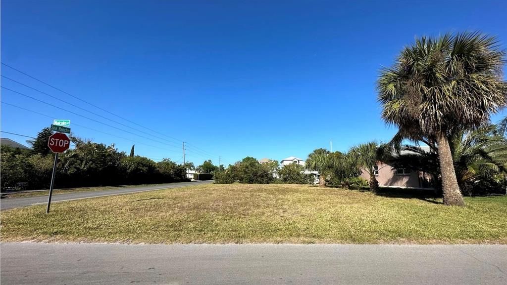 A vacant, grassy residential lot sits at a street corner with a stop sign — Lot 20 MALCOM AVENUE, HUDSON, FL