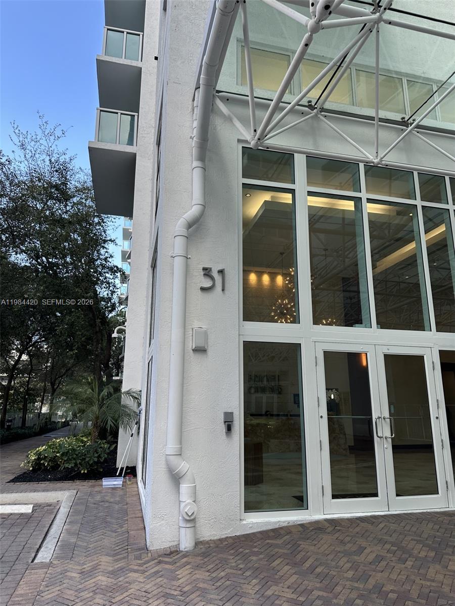 The exterior of a white building features the number 31 and a glass entrance — 31 SE 5th St # 3916, Miami FL 33131, MIAMI, FL