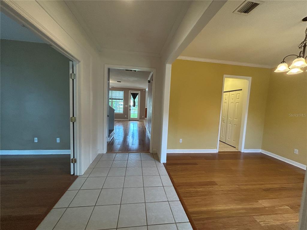 A tiled entryway leads to a dining room with hardwood floors and a yellow wall — 2549 TWAIN DRIVE, TALLAHASSEE, FL